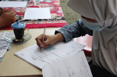 Petugas pelayanan keliling Dinas Kependudukan dan Pencatatan Sipil Provinsi DKI Jakarta membantu warga untuk mengurus data.