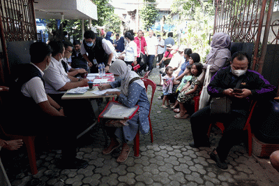 Petugas pelayanan keliling Dinas Kependudukan dan Pencatatan Sipil Provinsi DKI Jakarta membantu warga untuk mengurus data.