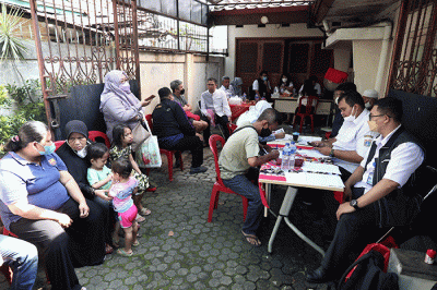 Petugas pelayanan keliling Dinas Kependudukan dan Pencatatan Sipil Provinsi DKI Jakarta membantu warga untuk mengurus data.