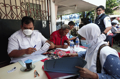 Petugas pelayanan keliling Dinas Kependudukan dan Pencatatan Sipil Provinsi DKI Jakarta membantu warga untuk mengurus data.