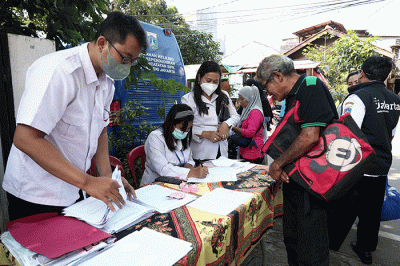 Petugas pelayanan keliling Dinas Kependudukan dan Pencatatan Sipil Provinsi DKI Jakarta membantu warga untuk mengurus data.