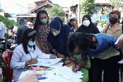 Petugas pelayanan keliling Dinas Kependudukan dan Pencatatan Sipil Provinsi DKI Jakarta membantu warga untuk mengurus data.