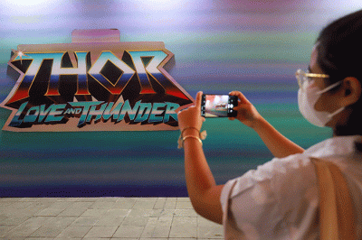 Warga berfoto berlatar mural promosi film Thor: Love and Thunder di Terowongan Kendal, Kawasan TOD Dukuh Atas, Jakarta Pusat, Rabu (6/7/2022).
