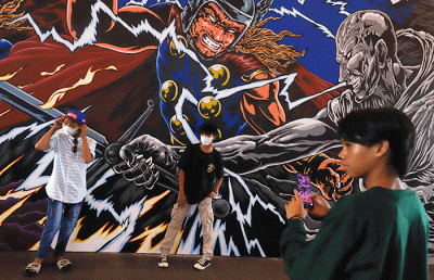 Warga berfoto berlatar mural promosi film Thor: Love and Thunder di Terowongan Kendal, Kawasan TOD Dukuh Atas, Jakarta Pusat, Rabu (6/7/2022).