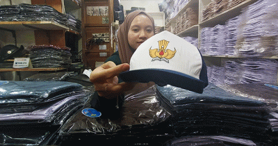 Penjual seragam sekolah melayani pembeli di Pasar Pondok Gede, Kota Bekasi, Jawa Barat, Jumat (8/7/2022).