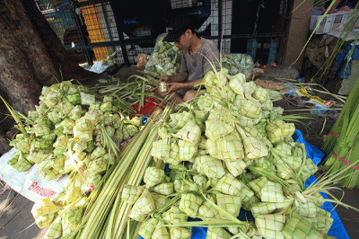 Pedagang membuat kulit ketupat untuk dijual di Pasar Palmerah, Jakarta, Sabtu (9/7/2022).