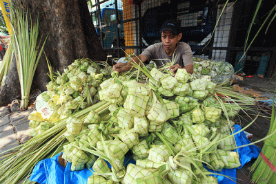 Pedagang membuat kulit ketupat untuk dijual di Pasar Palmerah, Jakarta, Sabtu (9/7/2022).