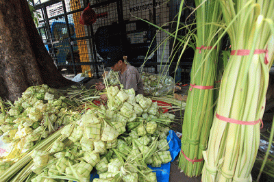 Pedagang membuat kulit ketupat untuk dijual di Pasar Palmerah, Jakarta, Sabtu (9/7/2022).