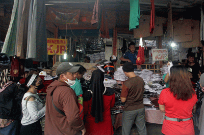 Orang tua memilih seragam sekolah baru untuk anaknya di salah satu kios di Pasar Kebayoran Lama, Jakarta, Sabtu (9/7/2022).
