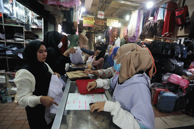 Orang tua memilih seragam sekolah baru untuk anaknya di salah satu kios di Pasar Kebayoran Lama, Jakarta, Sabtu (9/7/2022).