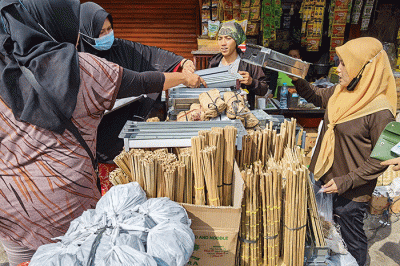 Pedagang saat melayani pembeli perlengkapan membuat sate di Jakarta Barat, Minggu (10/7/2022).
