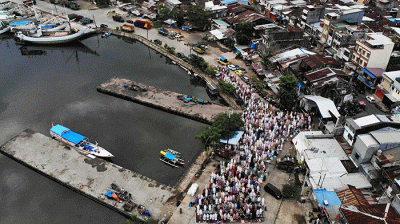 Foto udara sejumlah umat muslim menunaikan ibadah salat Idul Adha 1443 H di Pelabuhan Paotere Makassar, Minggu (10/7/2022).