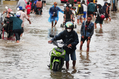 Warga melintasi banjir yang menggenangi Jalan KH Hasyim Ashari, Kota Tangerang, Banten, Sabtu (16/7/2022).