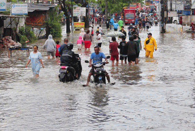 Warga melintasi banjir yang menggenangi Jalan KH Hasyim Ashari, Kota Tangerang, Banten, Sabtu (16/7/2022).