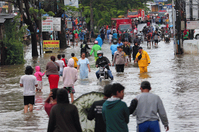 Warga melintasi banjir yang menggenangi Jalan KH Hasyim Ashari, Kota Tangerang, Banten, Sabtu (16/7/2022).