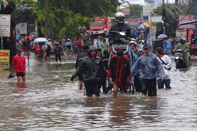 Warga memanfaatkan jasa gerobak untuk melewati banjir di Jalan KH Hasyim Ashari, Kota Tangerang, Banten, Sabtu (16/7/2022).