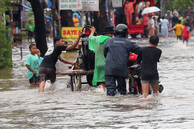 Warga memanfaatkan jasa gerobak untuk melewati banjir di Jalan KH Hasyim Ashari, Kota Tangerang, Banten, Sabtu (16/7/2022).
