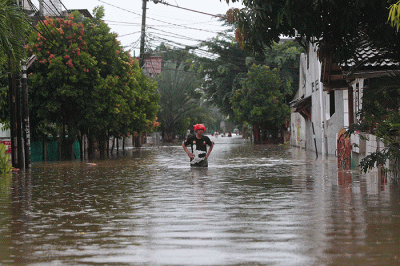 Warga melintasi banjir yang merendam Perumahan Ciledug Indah, Ciledug, Tangerang, Banten, Sabtu (16/7/2022).