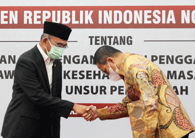 Menko PMK Muhadjir Effendy (kiri) mengangkat Ketua Dewas BPJS Kesehatan Abdul Kadir masa jabatan tahun 2021-2026, di Jakarta, Senin, (18/7/2022).