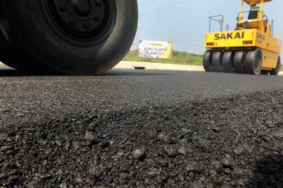 Pekerja menyelesaikan proyek pengaspalan plastik di kawasan BSD City, Tangerang, Banten, Kamis (21/7/2022).
