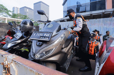 Sejumlah petugas gabungan yang terdiri dari Satpol PP dan Dinas Perhubungan (Dishub) DKI Jakarta memindahkan sepeda motor yang terparkir liar ke atas truk.