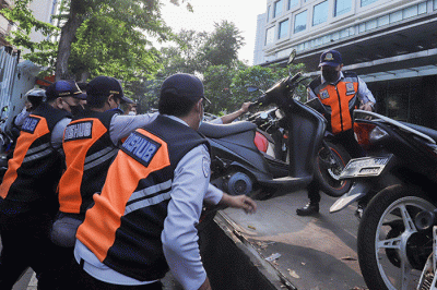 Sejumlah petugas gabungan yang terdiri dari Satpol PP dan Dinas Perhubungan (Dishub) DKI Jakarta memindahkan sepeda motor yang terparkir liar ke atas truk.