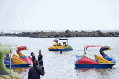 Sejumlah warga menikmati libur akhir pekan di Pantai Akkarena, Makassar, Minggu (31/7/2022).