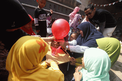 Perwakilan MNC Peduli (kanan) menyerahkan bantuan berupa peralatan perpustakaan kepada pendiri Rumah Baca Krukut Rahmi di Depok, Jawa Barat, Minggu (7/8/2022).