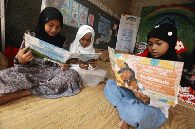 Perwakilan MNC Peduli (kanan) menyerahkan bantuan berupa peralatan perpustakaan kepada pendiri Rumah Baca Krukut Rahmi di Depok, Jawa Barat, Minggu (7/8/2022).