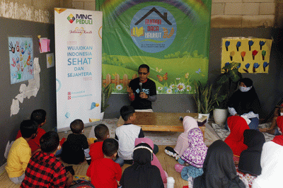 Perwakilan MNC Peduli (kanan) menyerahkan bantuan berupa peralatan perpustakaan kepada pendiri Rumah Baca Krukut Rahmi di Depok, Jawa Barat, Minggu (7/8/2022).