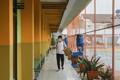 Petugas saat melakukan penyemprotan rutin cairan disinfektan di ruang kelas SMAN 113 Jakarta Timur, Selasa (9/8/2022).