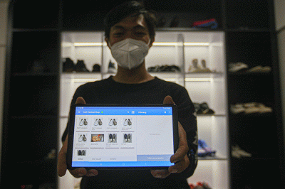 Pekerja saat menunjukan fitur layanan jasa cuci sepatu melalui aplikasi digital di Jakarta Timur, Senin (15/8/2022).