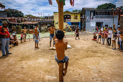 Sejumlah peserta lomba panjat pinang berusaha memanjat untuk meraih amplop berisi uang tunai di Jalan Malengkeri, Makassar, Rabu (17/8/2022).