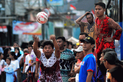 Warga berebut bola saat lomba sepak bola mengenakan kotum daster di Kampung Pulo, Jatinegara, Rabu (17/8/2022).