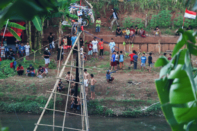 Sejumlah peserta saat berusaha mencapai puncak saat lomba panjat pinang di aliran Banjir Kanal Timur, Duren Sawit, Jakarta Timur, Minggu (21/8/2022).
