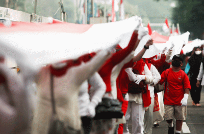 Ratusan warga kompak membawa Bendera Merah Putih sepanjang 1.700 meter di Jakarta, Minggu (28/8/2022).