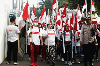 Ratusan warga kompak membawa Bendera Merah Putih sepanjang 1.700 meter di Jakarta, Minggu (28/8/2022).