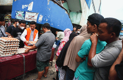 Menteri Perdagangan Zulkifli Hasan (tengah) saat membelikan telur ayam untuk warga di Bazar Pangan Murah, Pasar Minggu, Jakarta, Jumat (2/9/2022).