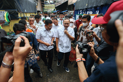 Menteri Perdagangan Zulkifli Hasan (tengah) saat membelikan telur ayam untuk warga di Bazar Pangan Murah, Pasar Minggu, Jakarta, Jumat (2/9/2022).