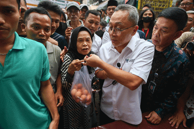 Menteri Perdagangan Zulkifli Hasan (tengah) saat membelikan telur ayam untuk warga di Bazar Pangan Murah, Pasar Minggu, Jakarta, Jumat (2/9/2022).
