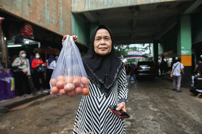 Menteri Perdagangan Zulkifli Hasan (tengah) saat membelikan telur ayam untuk warga di Bazar Pangan Murah, Pasar Minggu, Jakarta, Jumat (2/9/2022).