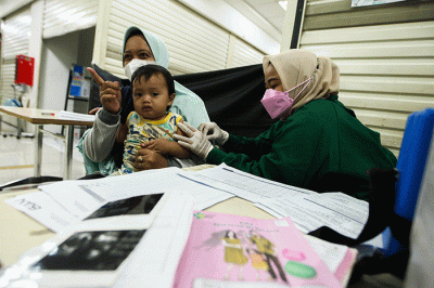Petugas medis saat memberikan suntikan vaksin campak-rubella untuk Anak dalam program Bulan Imunisasi Anak Nasional (BIAN) di Mal Tamini Square.