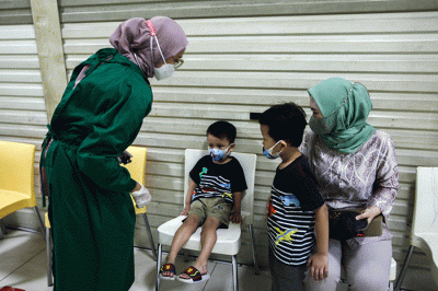 Petugas medis saat memberikan suntikan vaksin campak-rubella untuk Anak dalam program Bulan Imunisasi Anak Nasional (BIAN) di Mal Tamini Square.
