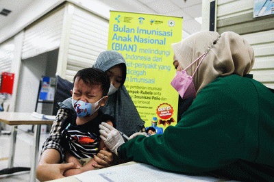 Petugas medis saat memberikan suntikan vaksin campak-rubella untuk Anak dalam program Bulan Imunisasi Anak Nasional (BIAN) di Mal Tamini Square.
