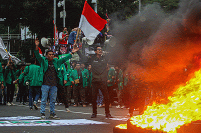Mahasiswa melompati api dari bakaran ban bekas saat aksi demo tolak kenaikan harga BBM di kawasan Patung Kuda, Jakarta, Jumat (9/9/2022).