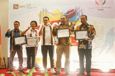 General Manager Merlynn Park Hotel Adolf Gustaf (kiri) saat menyerahkan penghargaan untuk atlet senior bulu tangkis Icuk Sugiarto.