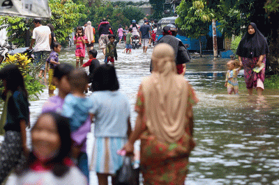 Warga melintasi banjir di permukiman di Kawasan Ciledug Indah, Tangerang, Minggu (11/9/2022).