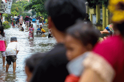 Warga melintasi banjir di permukiman di Kawasan Ciledug Indah, Tangerang, Minggu (11/9/2022).
