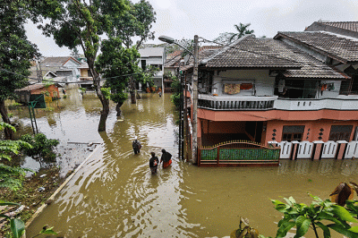 Warga melintasi banjir di permukiman di Kawasan Ciledug Indah, Tangerang, Minggu (11/9/2022).