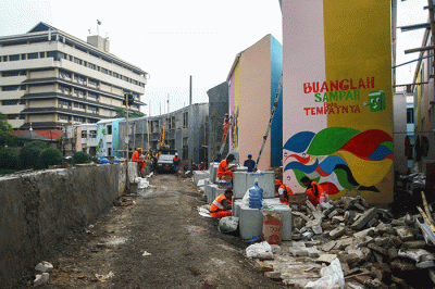 Petugas PPSU membuat mural disalah satu bangunan Kampung Gembira di kawasan Pasar Gembrong, Jakarta Timur, Selasa (13/9/2022).